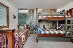 een slaapkamer met 2 stapelbedden en een muurschildering bij Pines Lake Chalet in Locust Lakes Village