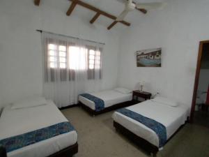 a room with three beds and a window at Casa Campestre Villa Margarita in Honda