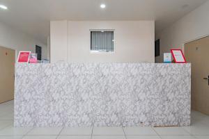 un grand mur blanc dans une chambre avec une fenêtre dans l'établissement RedDoorz near Prujakan Station Cirebon, à Cirebon