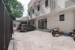 une voiture garée dans un parking à côté d'un bâtiment dans l'établissement RedDoorz near Prujakan Station Cirebon, à Cirebon