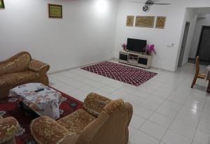 a living room with a couch and a tv at Homestay UmahMak in Bandar Puncak Alam