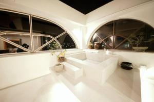 a white room with two windows and a large white tub at ORMAK the House in Gangneung