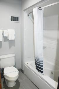 a white bathroom with a toilet and a shower at Greenlight Inn & Suites St James in Saint James