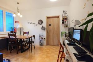 a dining room with a table and a desk with a computer at Goodlebang, 3 bed room apartment, Center Ljubljana in Ljubljana