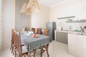 a kitchen with a table and chairs in a kitchen at D'Minggiran by Plesirhatiyogya in Timuran +5 photos
