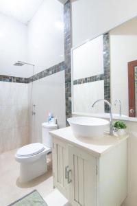 a bathroom with a white sink and a toilet at D'Minggiran by Plesirhatiyogya in Timuran