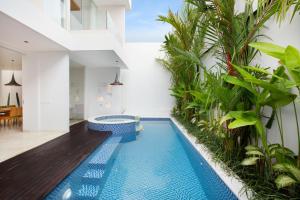 スミニャックにあるEight Palms Villa Seminyak by Ini Vie Hospitalityの植物の家の中央にあるスイミングプール +66枚の写真