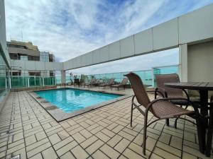 a balcony with a swimming pool on a building at Thuis I Apê Incrível na Praia do Canto + Garagem in Vitória