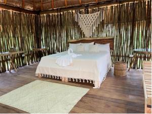 - une chambre avec un lit dans une cabane en paille dans l'établissement Hotel Jungla y Estrellas, à Cobá