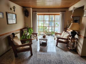 uma sala de estar cheia de mobiliário e uma grande janela em Hostal Rio Ona em Ushuaia