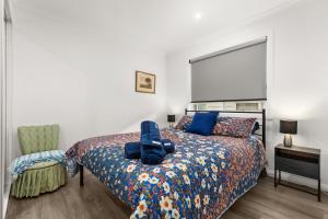 a bedroom with a bed and a chair and a window at Libbity's at The Point by Experience Jervis Bay in Sanctuary Point
