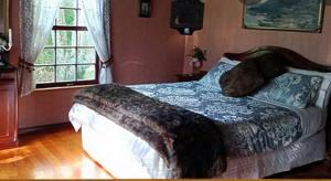 una camera da letto con un letto con una coperta sopra di Warm Earth Cottages a Aongatete Altre 43 foto