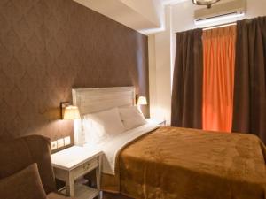 1 dormitorio con 1 cama, 1 silla y 1 ventana en Fotis Rooms en Skafidia