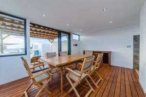 a dining room with a wooden table and chairs at One Bay Residence Unit 15 - Penthouse with private roof top, jacuzzi and sea view in Grand Baie
