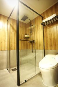 a bathroom with a glass shower with a toilet at Gumi Century Hotel in Gumi