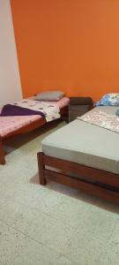 圣希尔Espectacular y céntrico apartamento en el corazón de San Gil 1的橙色墙壁的房间里设有三张床 更多9张照片