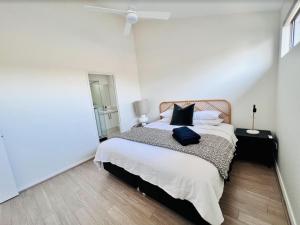 a bedroom with a large bed with white walls at Tranquil Tree Views 2 Bedroom 2 Bathroom Apartment in Perth