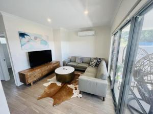 uma sala de estar com um sofá e uma televisão em Tranquil Tree Views 2 Bedroom 2 Bathroom Apartment em Perth