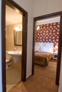 a bathroom with a bedroom with a bed and a sink at Fotis Rooms in Skafidia
