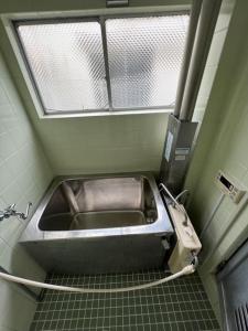 lavandino in metallo in bagno con finestra di G&R House302 a Tokyo