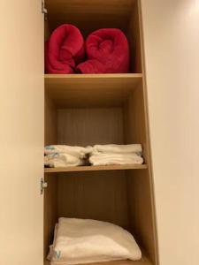 un armario con 2 almohadas rojas y toallas en Ótimo Apartamento no coração da Ponta Verde, en Maceió