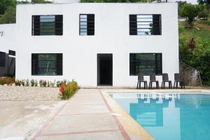 une maison blanche avec une piscine en face de celle-ci dans l'établissement VILLA MAJO, à Melgar