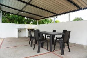 - une table et des chaises noires sur la terrasse dans l'établissement VILLA MAJO, à Melgar