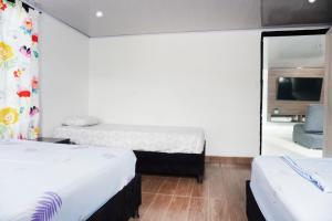 sypialnia z 2 łóżkami i dużym lustrem w obiekcie VILLA MAJO w mieście Melgar