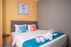 a bedroom with a bed with towels on it at Sans Hotel Fourth Loft Solo in Solo