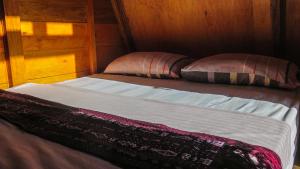 uma cama com duas almofadas em cima em Sinuan Homestay 