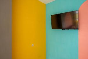 a room with colorful walls and a tv on a wall at Sans Hotel Fourth Loft Solo in Solo