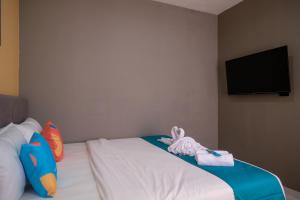 a bedroom with a bed with stuffed animals on it at Sans Hotel Fourth Loft Solo in Solo