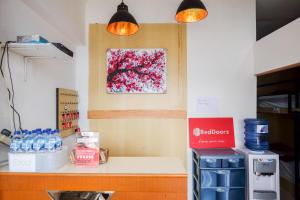 a kitchen with a counter with a tree painting on the wall at RedDoorz Hostel near Lawang Sewu Semarang in Kalibanteng-lor