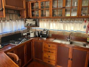 uma cozinha com um lavatório e um fogão forno superior em Storyhouse in Kommetjie em Kommetjie