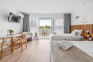 a bedroom with two beds and a table and a dining room at Mollymook Motel in Mollymook