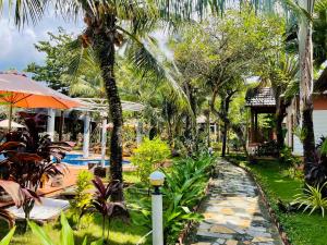 a garden with a pathway leading to a resort at Orange Resort in Phu Quoc