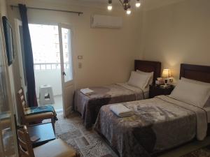 a hotel room with two beds and a window at Elites 1 in Alexandria
