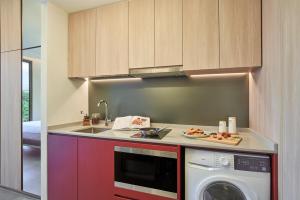 a kitchen with a sink and a washing machine at Citadines Connect Rochester Singapore in Singapore