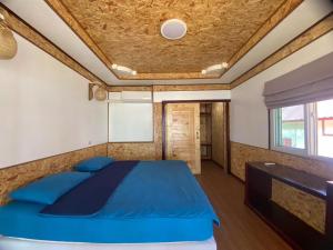 a bedroom with a blue bed in a room at Sunrise House in Ko Yao Noi