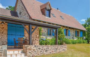 a stone house with blue doors and a table and chairs at Amazing Home In St Priest La Fougeres in La Coquille +28 photos