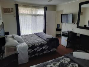 ein Hotelzimmer mit 2 Betten und einem Fenster in der Unterkunft Flying Spur Motel in Toowoomba