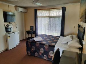 um quarto de hotel com uma cama e uma janela em Flying Spur Motel em Toowoomba