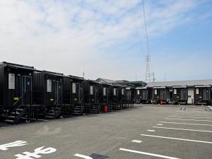 una fila de vagones estacionados en un estacionamiento en HOTEL R9 The Yard Shikokuchuo, en Shikokuchuo