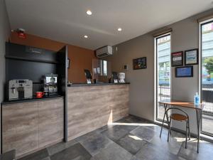 四国中央市にあるHOTEL R9 The Yard 四国中央のカウンターとテーブルのあるコーヒーショップ