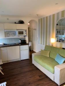 Una sala de estar con un sofá y una cocina. en Between Piers, the stylish studio flat in Cannon place, en Brighton & Hove