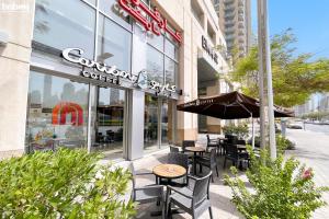 a cafe with tables and chairs in front of a building at bnbmehomes - Spacious Studio in Downtown Near Burj Khalifa - 1703 in Dubai