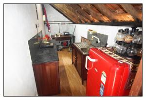una piccola cucina con frigorifero rosso in camera di Munroe Inn Homestay a Kollam