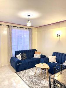 a living room with a blue couch and a table at Cosy and spacious apartment in Meru in Meru