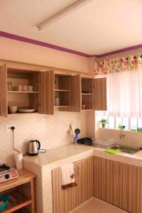 a kitchen with wooden cabinets and a counter top at Cosy and spacious apartment in Meru in Meru