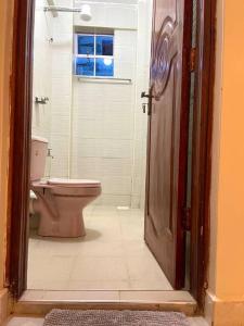 a bathroom with a toilet and a glass door at Cosy and spacious apartment in Meru in Meru